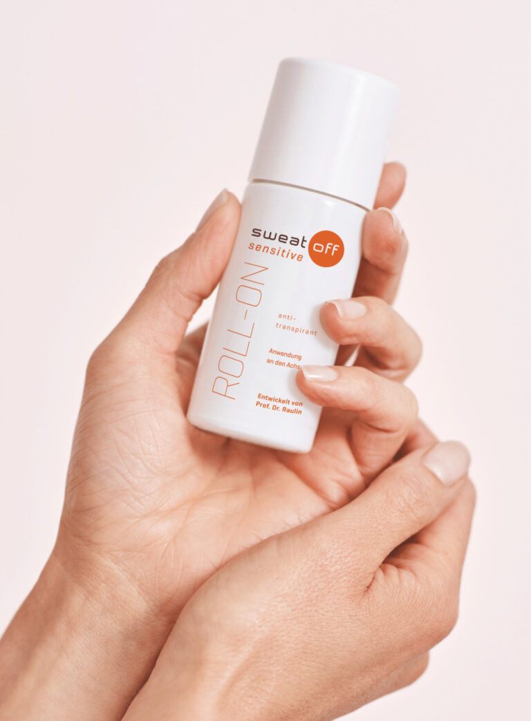 Antitranspirant Sensitive Roll-On in Hand vor Rosa Hintergrund