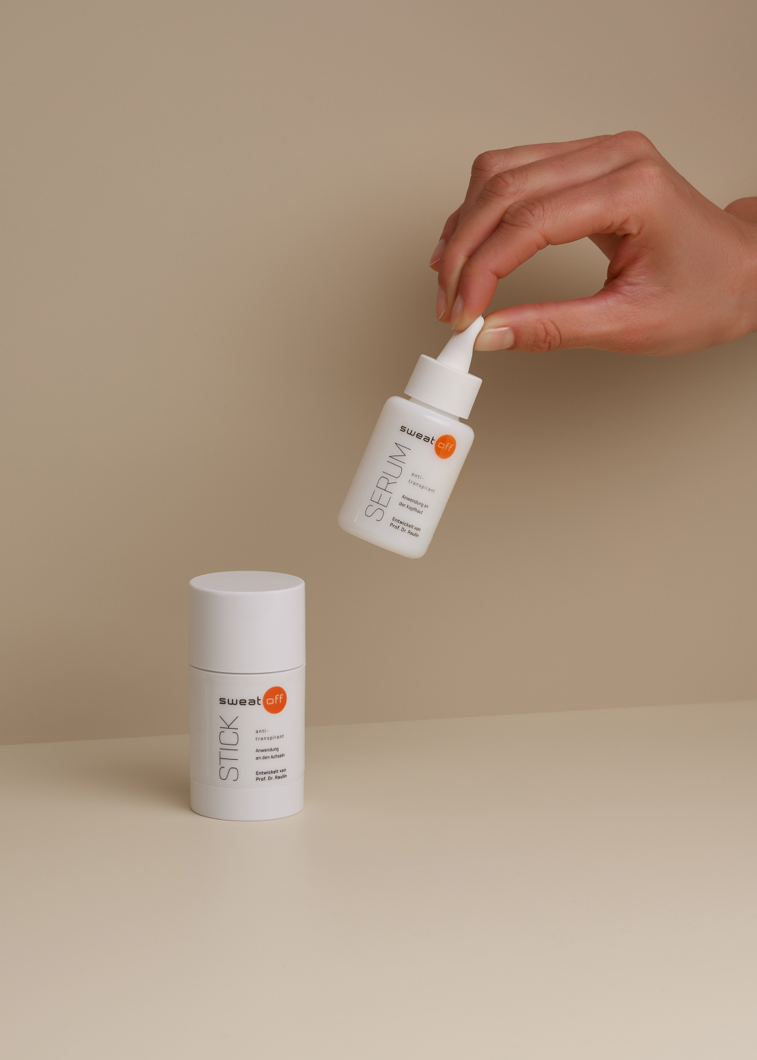 Antitranspirant Stick und Serum, das Serum wird von einer Hand hochgehoben